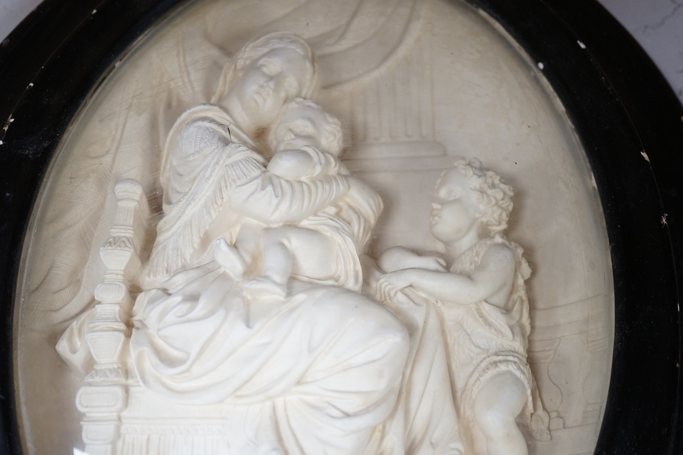 A pair of framed plaster ovals of the Madonna and Child with John the Baptist and the 'Descent from the Cross' 41x33cm